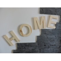 Mot "HOME" en bois de pin accroché sur un mur.